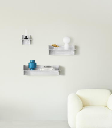 Prateleiras de parede transparentes Normann Copenhagen com acessórios decorativos num espaço minimalista.