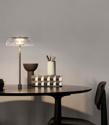 Candeeiro de mesa elegante numa secretária moderna com acessórios de decoração elegantes.