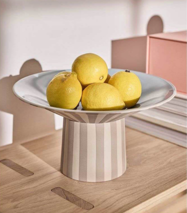 Taça OY OY Living com limões sobre uma elegante mesa de madeira em suaves tons pastel.