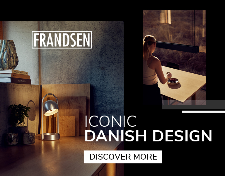 Nordic interior with a metallic Frandsen table lamp and Scandinavian dining area, promoting iconic Danish lighting design.
